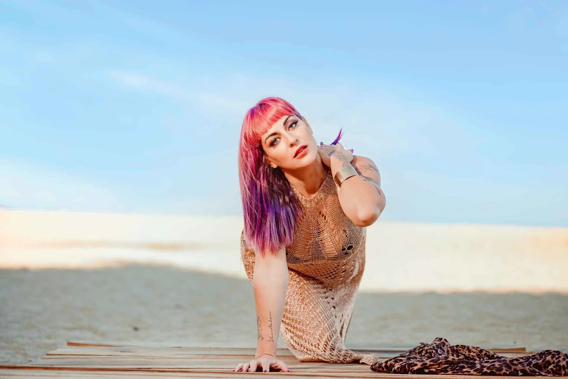 Retrato con cabello rosa sobre una pasarela en la playa
